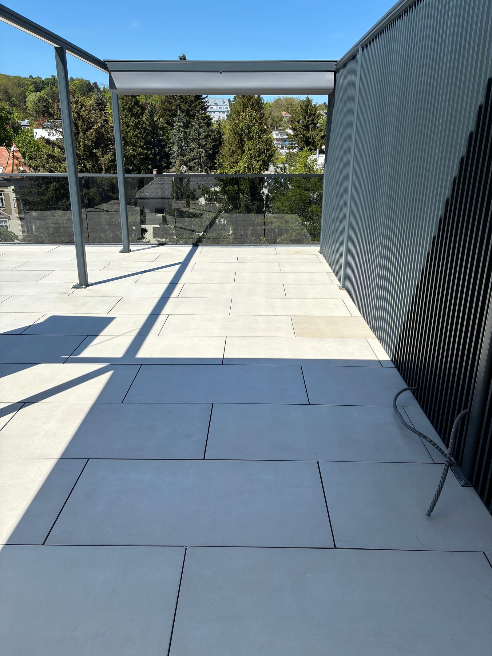 Frisch gereinigte Dachterrasse mit hellgrauen Betonplatten